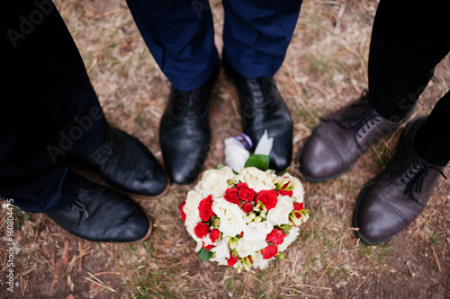 Handsome groom with cool groomsmen walking in the forest and having fun on a wedding day.