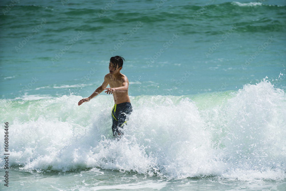 Beautiful young boy playing in the waves Beautiful young boy playing in the waves