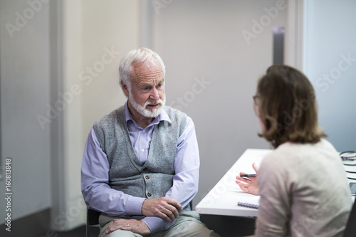Female Medical Doctor listening to a Senior patient symptoms photo