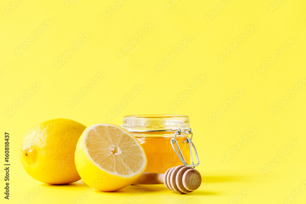 Jar of honey a wooden spoon and lemons Jar of honey a wooden spoon and lemons