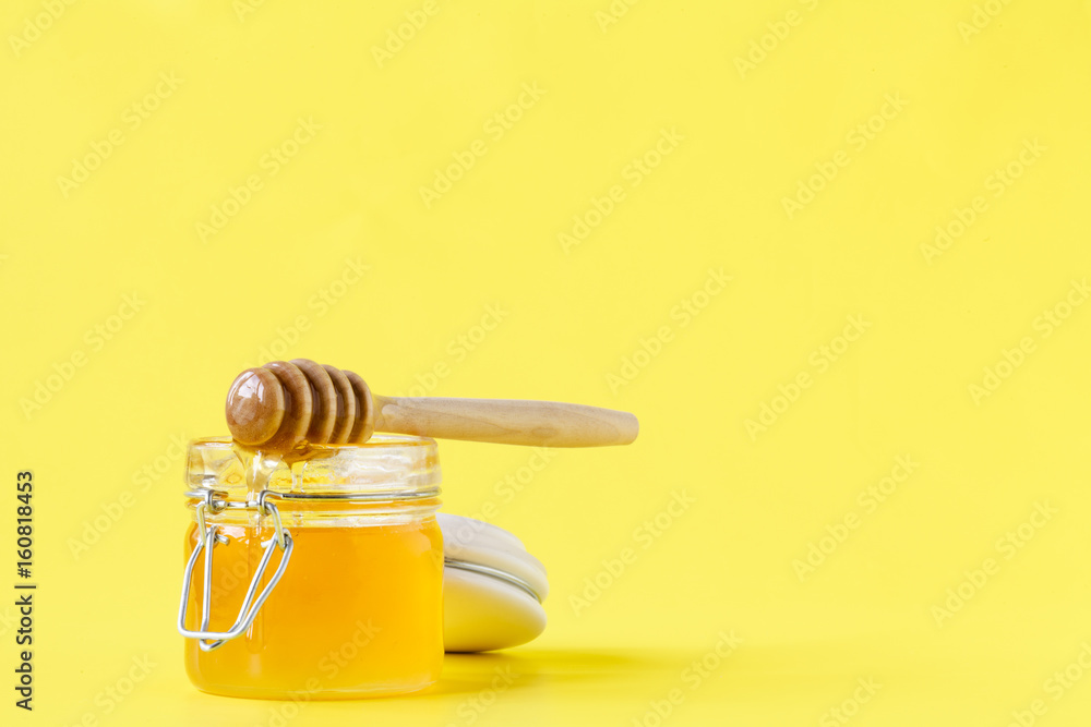 Honey dropping from dipper into a jar Honey dropping from dipper into a jar