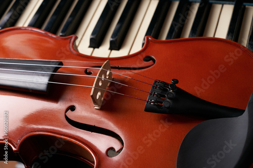Photography Classical musical stringed instrument violin on piano keys