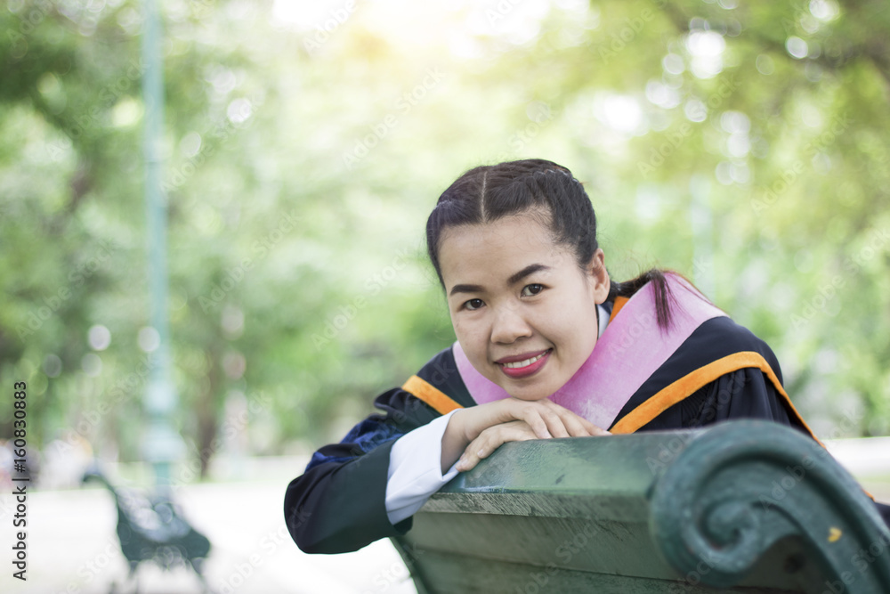Happy and glad graduated Asian student siting on arm shair in park, congratulations, graduate education success, concept education and finished learning in class Happy and glad graduated Asian student siting on arm shair in park, congratulations, graduate education success, concept education and finished learning in class