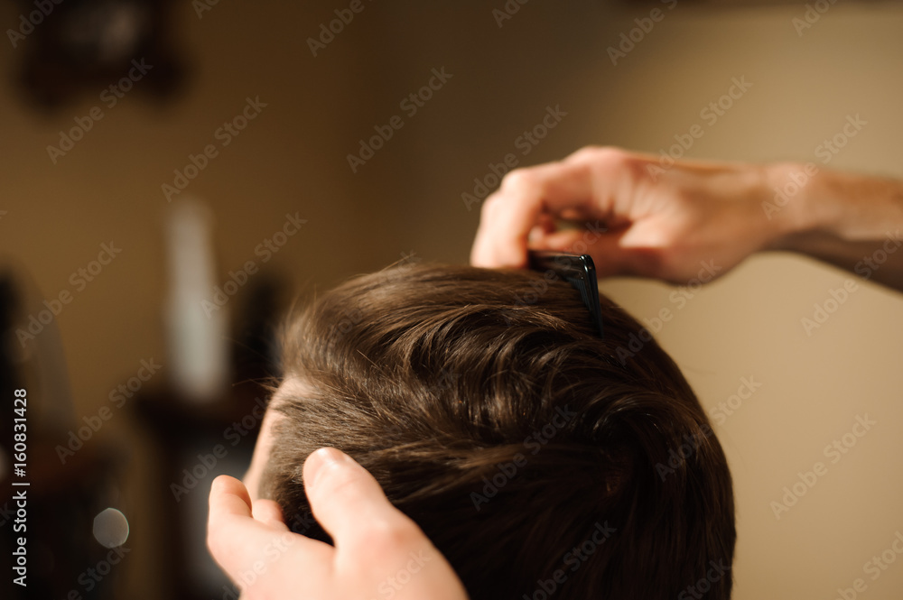 Fototapeta premium Master cuts hair and beard of men in the barbershop