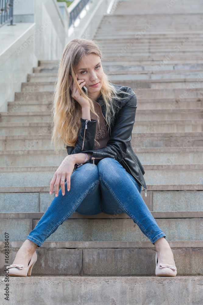 Girl with cell phone on the stone stairs Girl with cell phone on the stone stairs