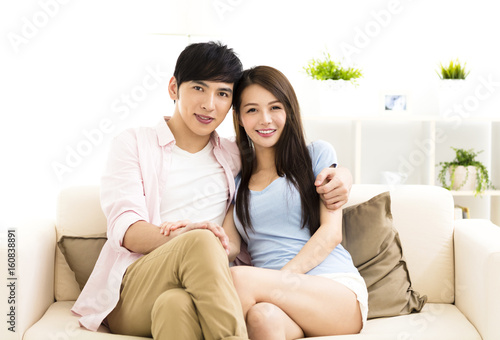 Portrait of  smiling  young couple sitting on sofa
