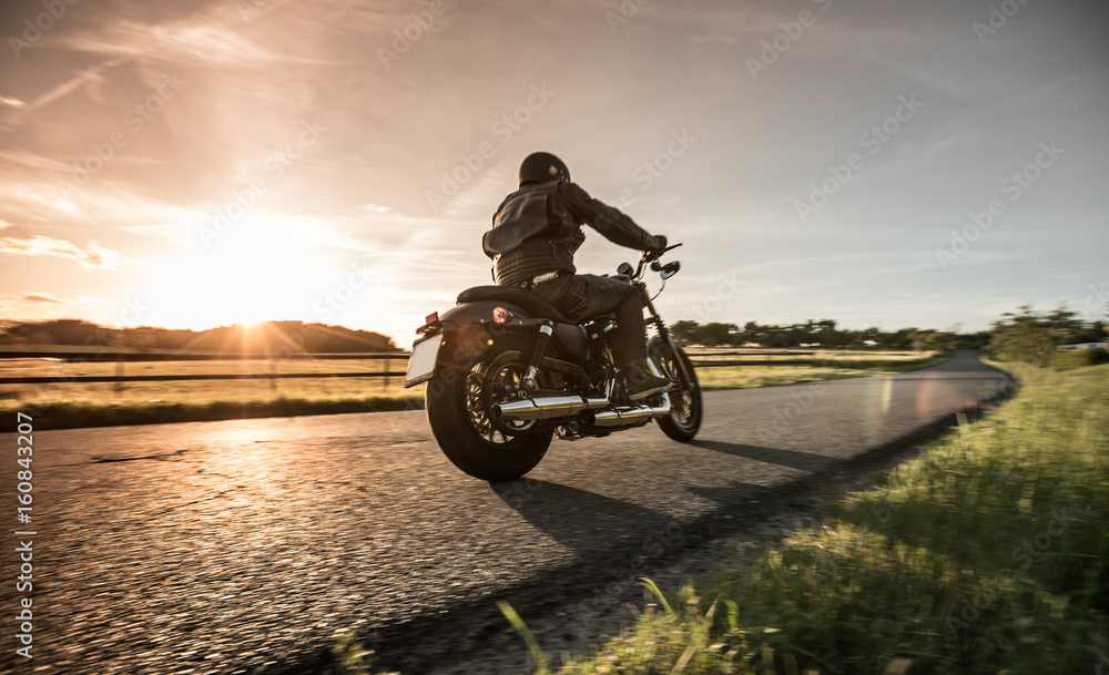 Fototapeta Mężczyzna jedzie sportster motocykl podczas zmierzchu.