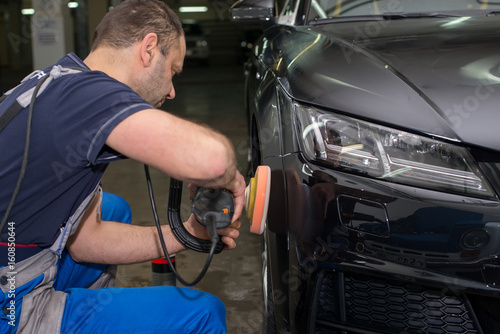 A man polishes a black car