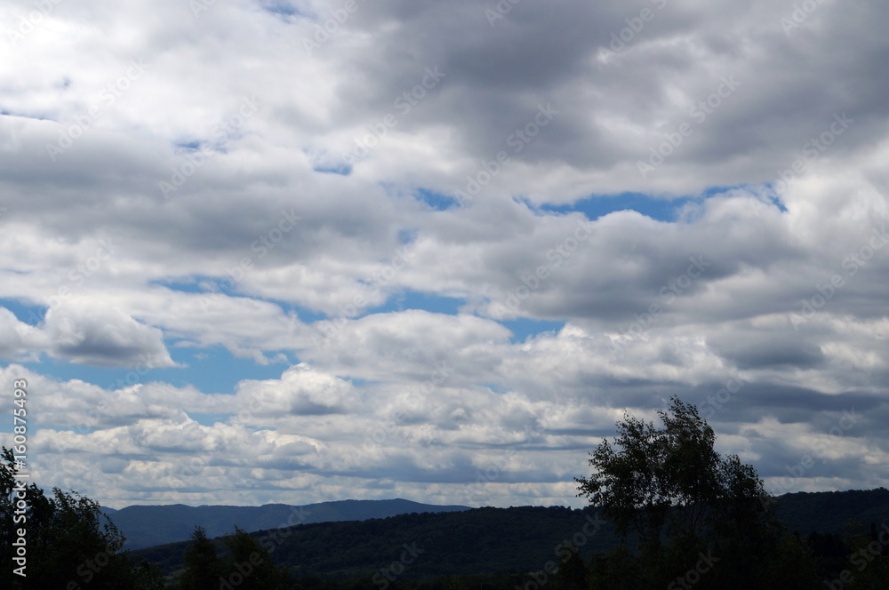 A view of the Carpathian mountains under the blue sky and white clouds