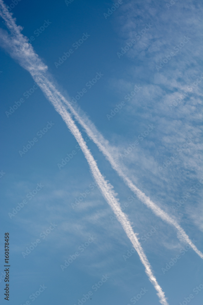 Two diagonal chem trails from airplanes in the blue sky Two diagonal chem trails from airplanes in the blue sky