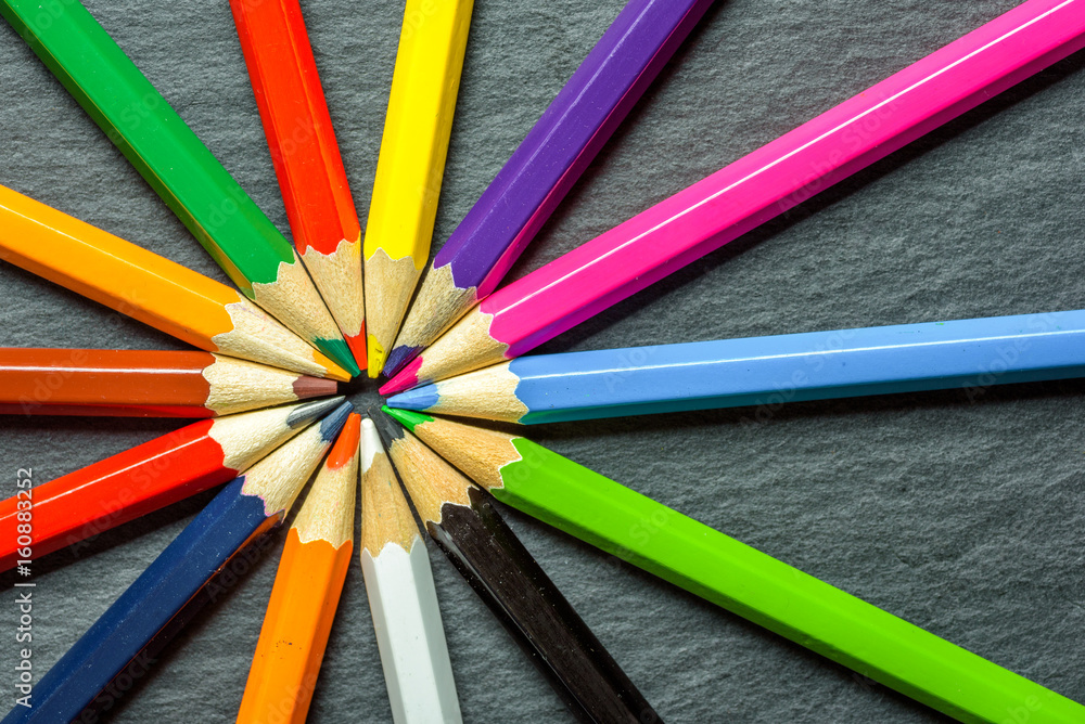 Naklejka premium Many different colored pencils neatly folded on wooden table background