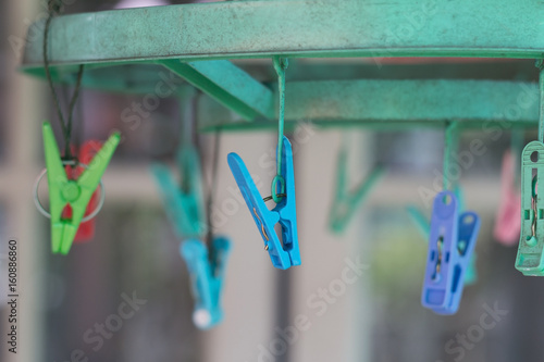Clothes pegs or clothespins hang on a cord. Plastic clothes pegs on a washing line.(selective focus)