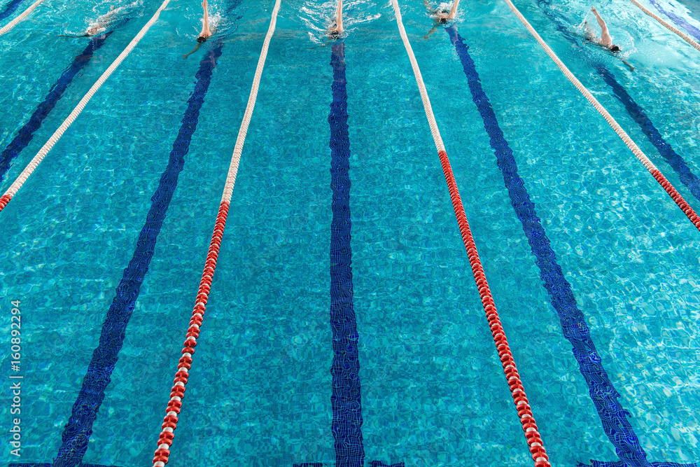 Five male swimmers racing against each other