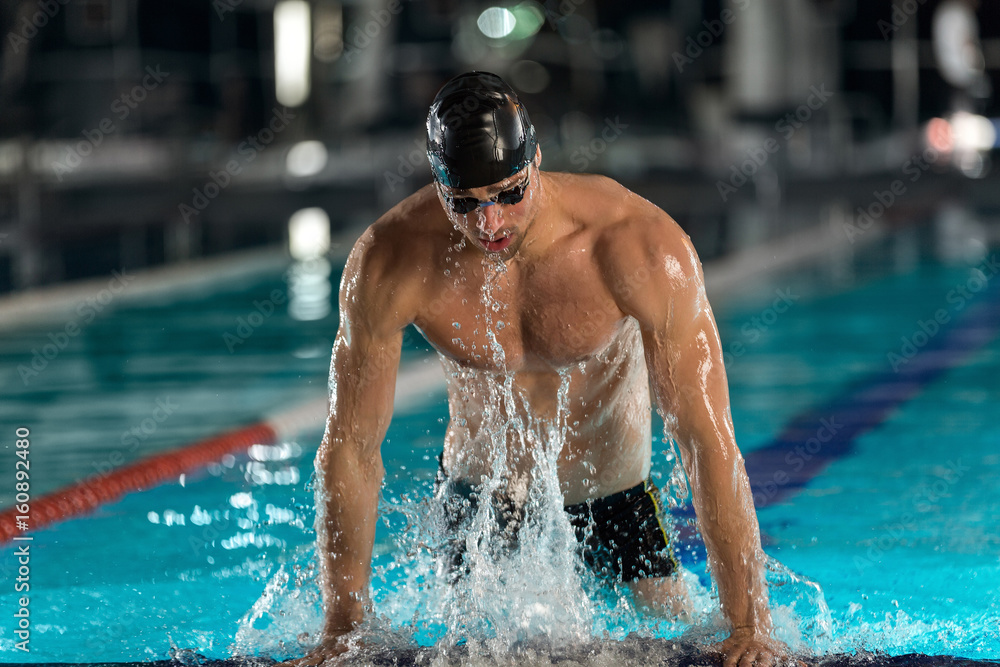 Male swimmer lifting himself out