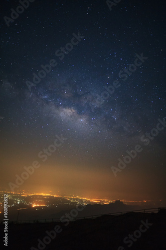 milky way galaxy and city light at Phutabberk Phetchabun in Thailand.Long exposure photograph.With grain