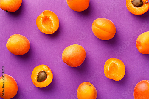 Apricot pattern. Top view of fresh fruit on a purple background. Repetition concept