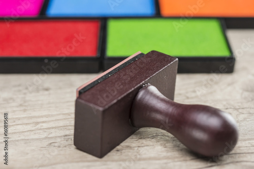 Close up shot of rubber stamp and multiple colors of ink boxes