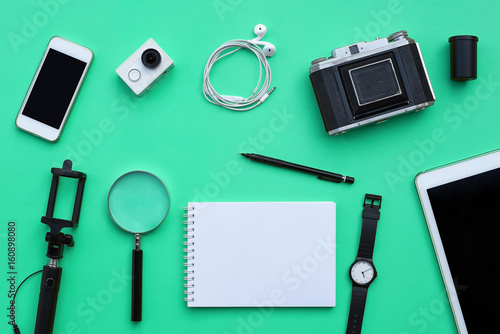 Flat lay of accessories on green desk background