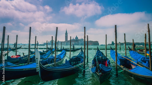 Gondolas moored by Saint Mark square with San Giorgio di Maggiore church in Venice, Italy © Surajet.L