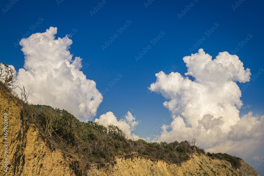 Quaint clouds on the mountainside on the horizon