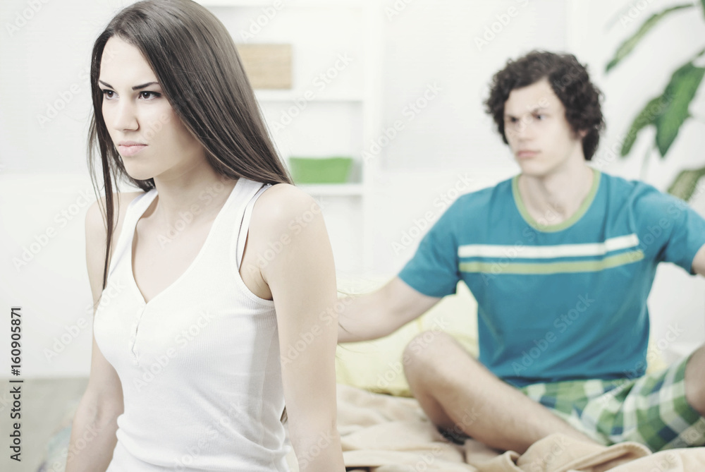 Angry and unhappy young couple in bed