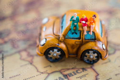 The concept of traveler. Miniature people sitting on vintage car over the map © nattaponsa