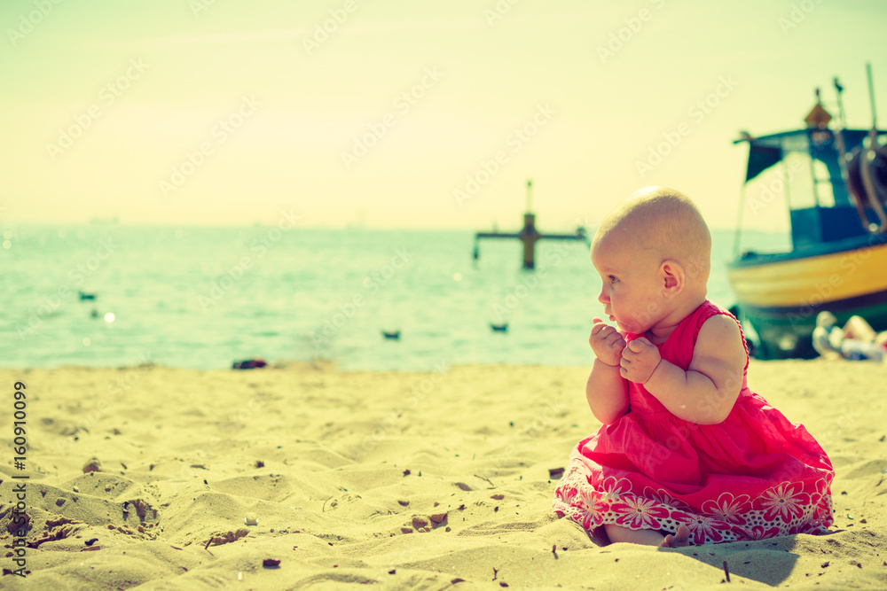 Little baby sitting, hands close to mouth Little baby sitting, hands close to mouth