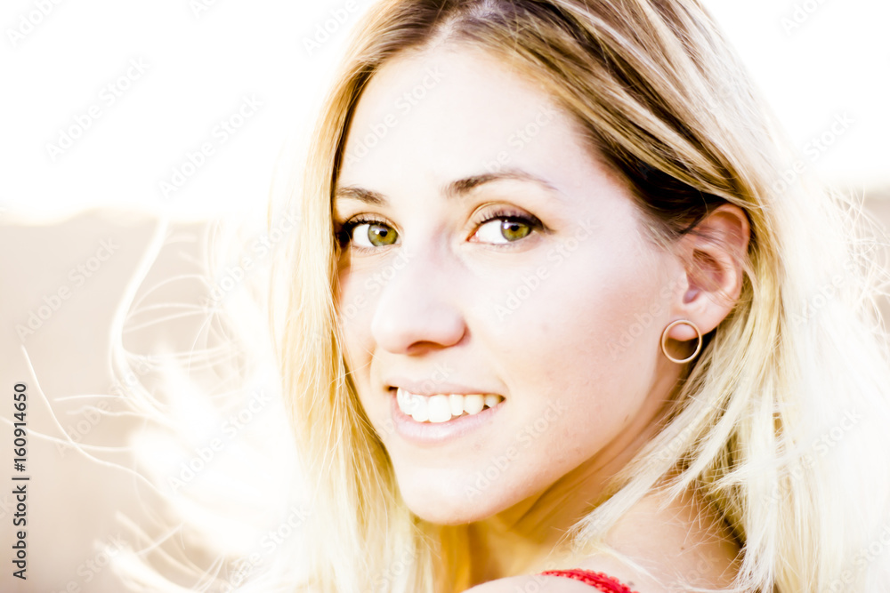 Beautiful blond woman in a red dress, on a wheat field at sunset Beautiful blond woman in a red dress, on a wheat field at sunset