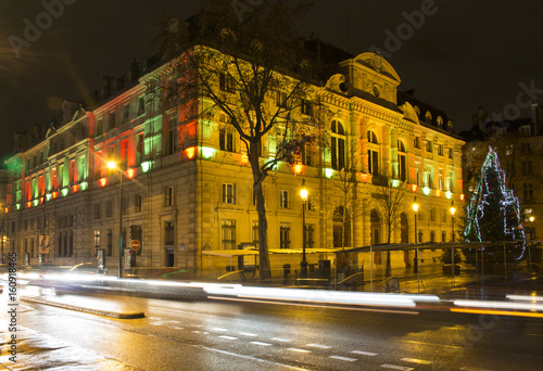 View of Mayor of the 4th Arrondissement building at night in Paris. Light trails of cars in motion create dramatic and dynamic ambiance.