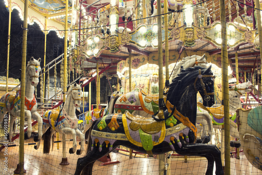 Close up view of horses of a carousel in front of Hotel De Ville Paris. Childhood, nostalgic fun concept.