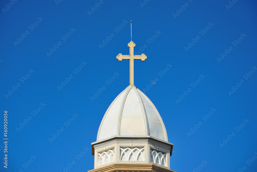 Cross on church roof with blue sky background in Thailand. Peace be unto the world.