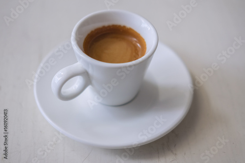 White cup of coffee on a vintage table
