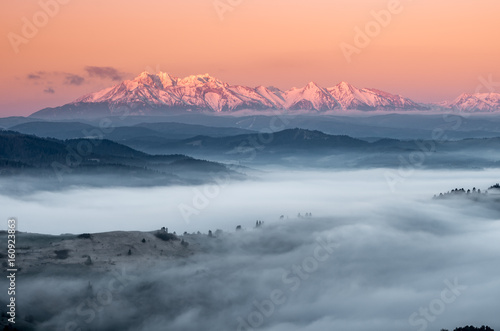 panorama over misty Spisz highland to snowy Tatra mountains in the morning, Poland landscape