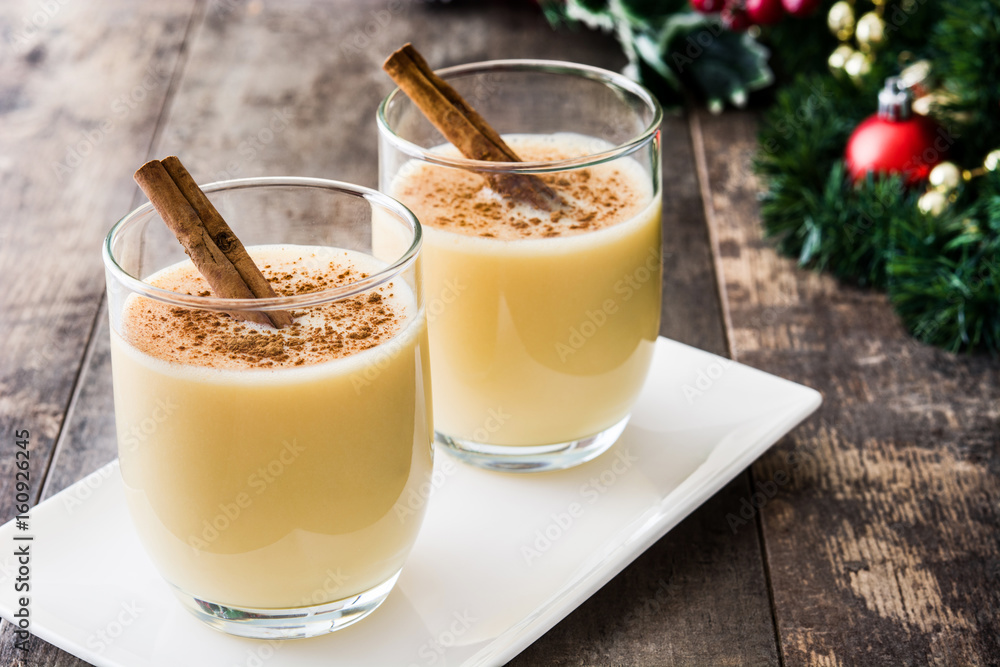 Homemade eggnog with cinnamon on wooden table. Typical Christmas dessert.
Homemade eggnog with cinnamon on wooden table. Typical Christmas dessert.