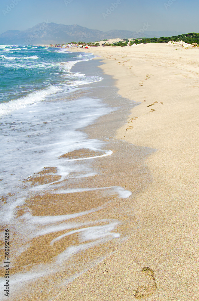 Obraz premium Footprints in the sand, the sea and the beach