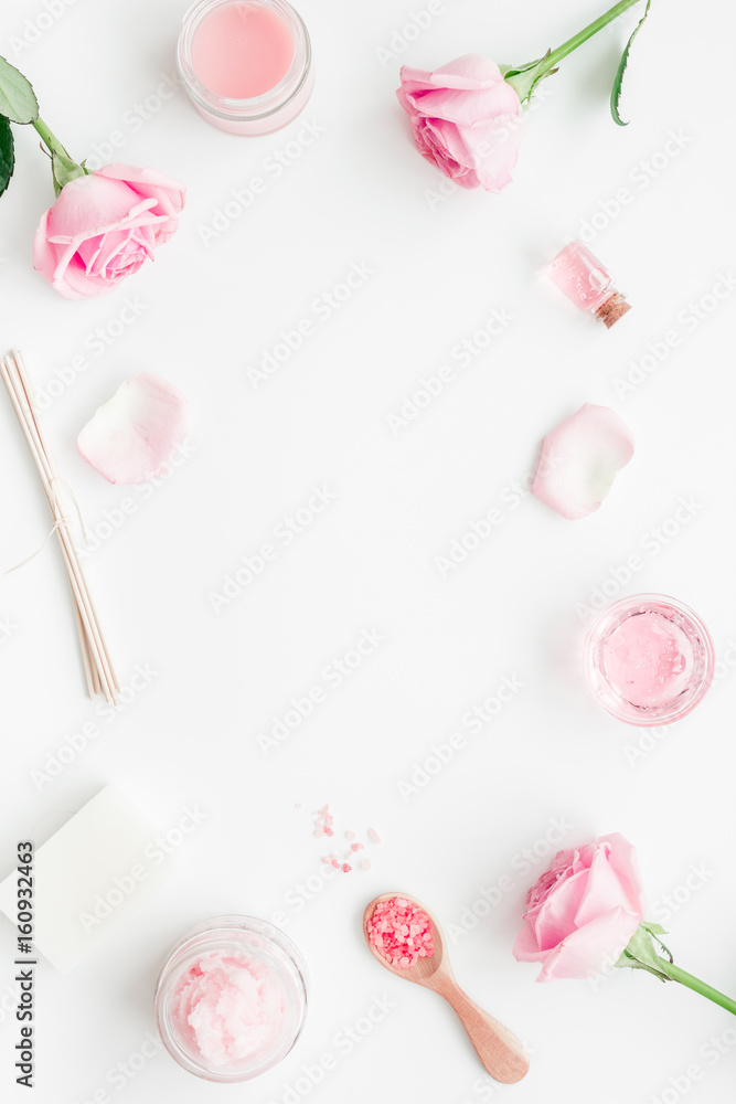 cosmetic set with rose blossom and body cream on white desk background top view mock-up