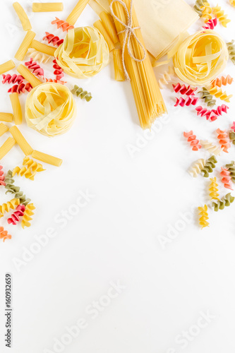 Assortment of different shape italian pastas on white background top view copyspace