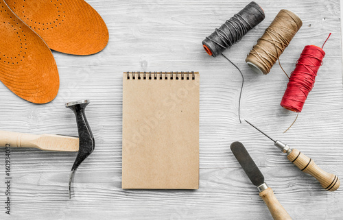 Cobbler takes order. Notebok on grey wooden desk background top view mockup photo