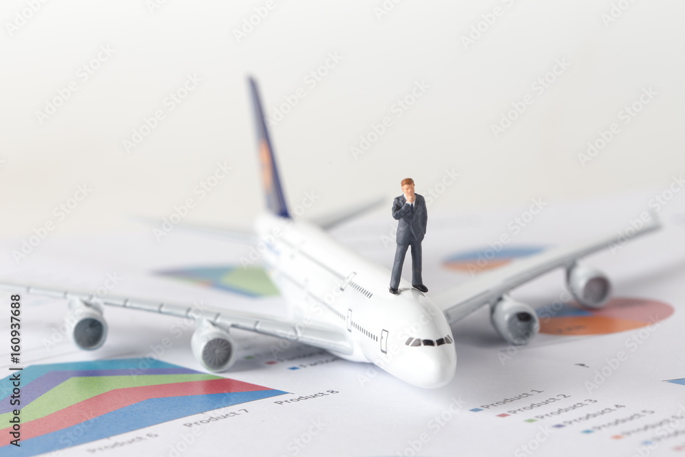 Miniature model of businessman standing on top of airplane and thinking for project of airline investment. Miniature model of businessman standing on top of airplane and thinking for project of airline investment.