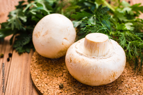 Close-up of fresh champignons and parsley on a wooden table