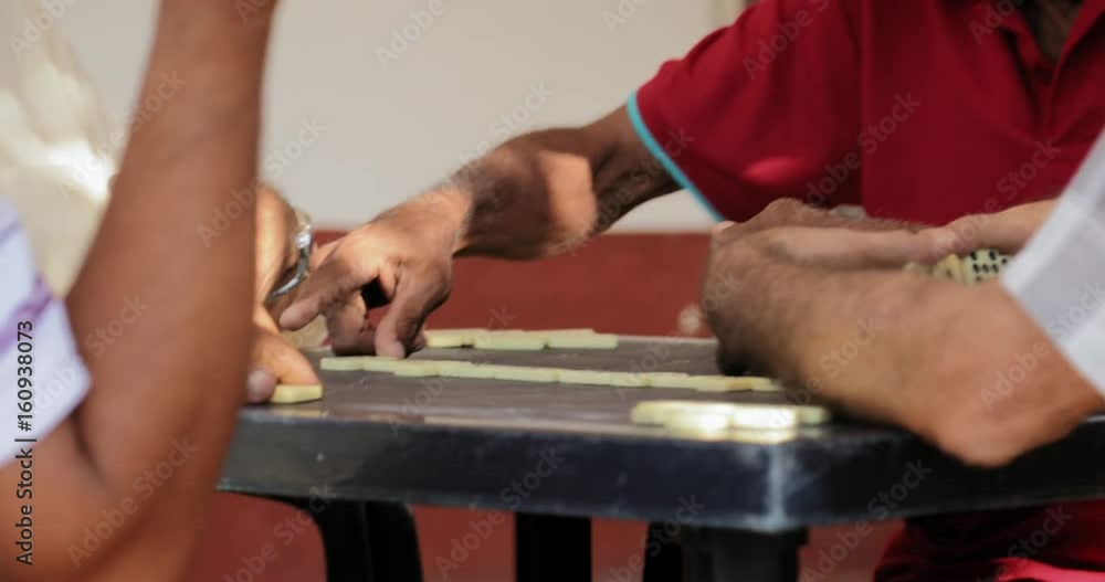 Hispanic Man Talking To Friend And Playing Domino Game Hispanic Man Talking To Friend And Playing Domino Game
