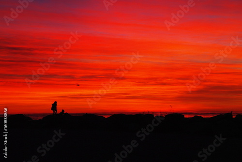 child in front of red sky after sunset