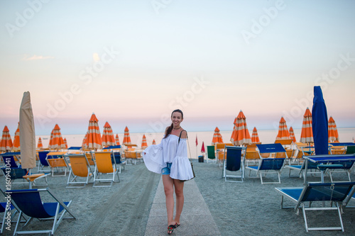 Young woman enjoying summer day on the beach in the sunset. Beach vacation in Europe