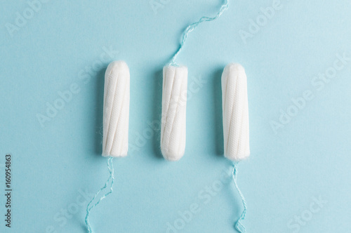 Menstrual tampon on a blue background. Menstruation time. Hygiene and protection photo