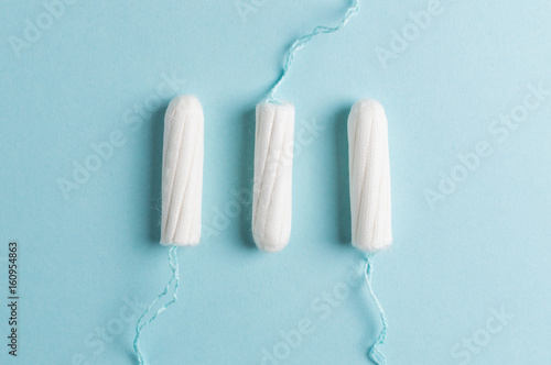 Menstrual tampon on a blue background. Menstruation time. Hygiene and protection