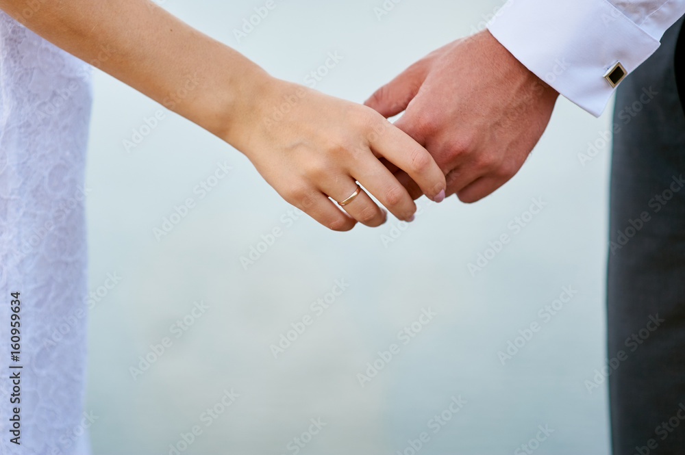 Beautiful wedding couple, bride and groom holding hands Beautiful wedding couple, bride and groom holding hands