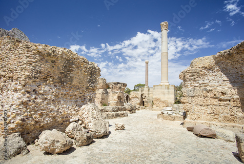stones and ruin with column under blue sky in Carthage in Tunisia