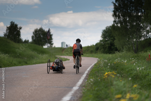 Man ride bycicle and his friend ride recumbent