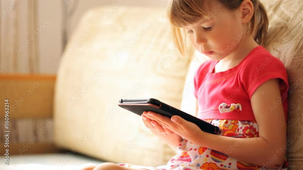 Little girl holding the e-book in her hand's Little girl holding the e-book in her hand's