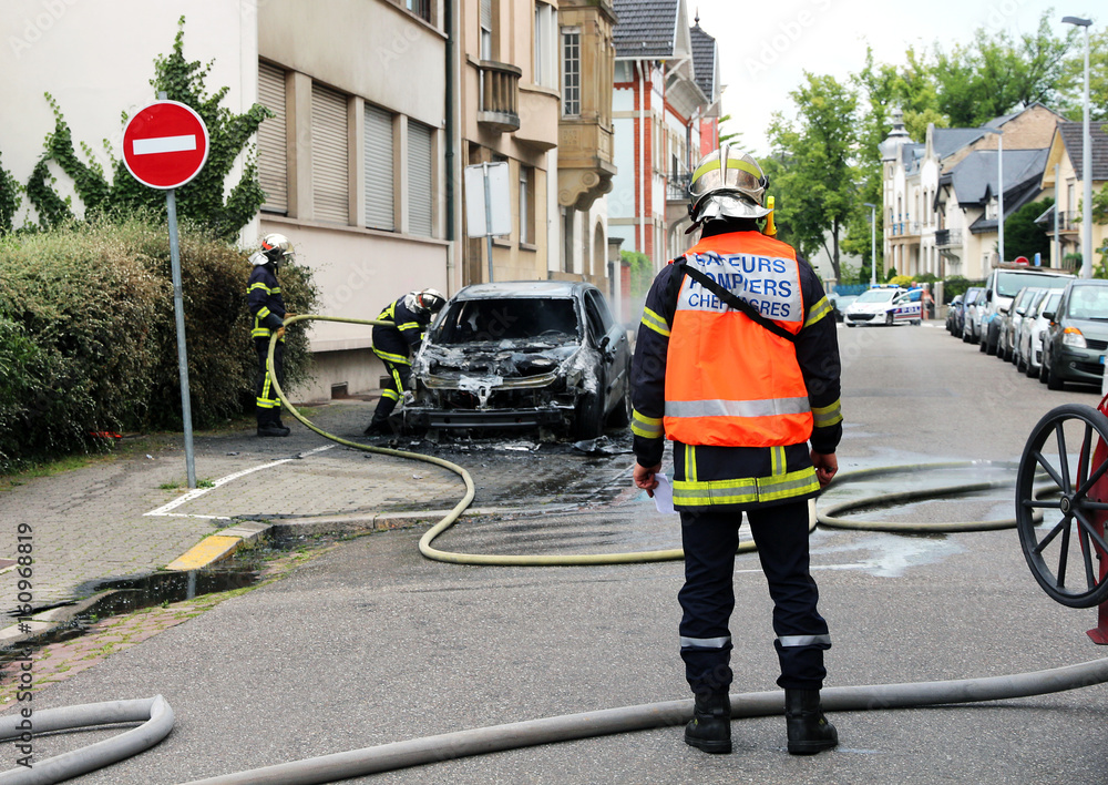 Fototapeta premium Burnt out car and firemen